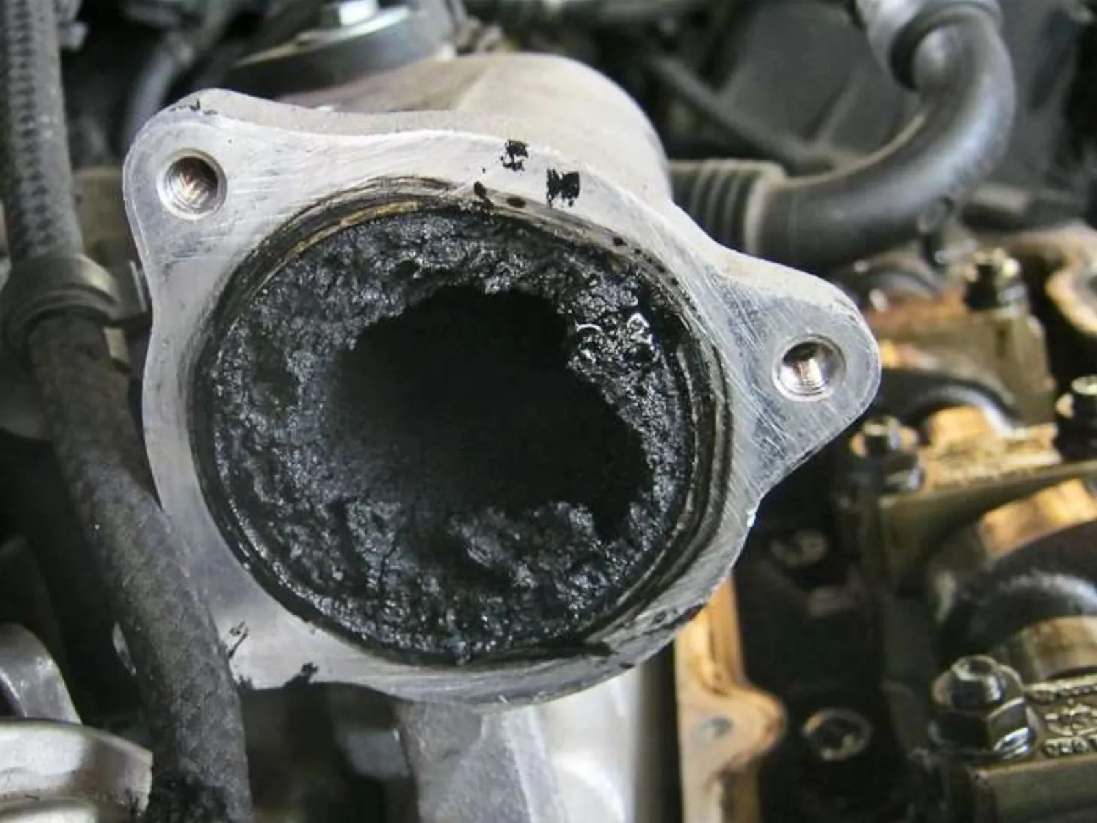 Diesel intake port heavily clogged with thick black carbon